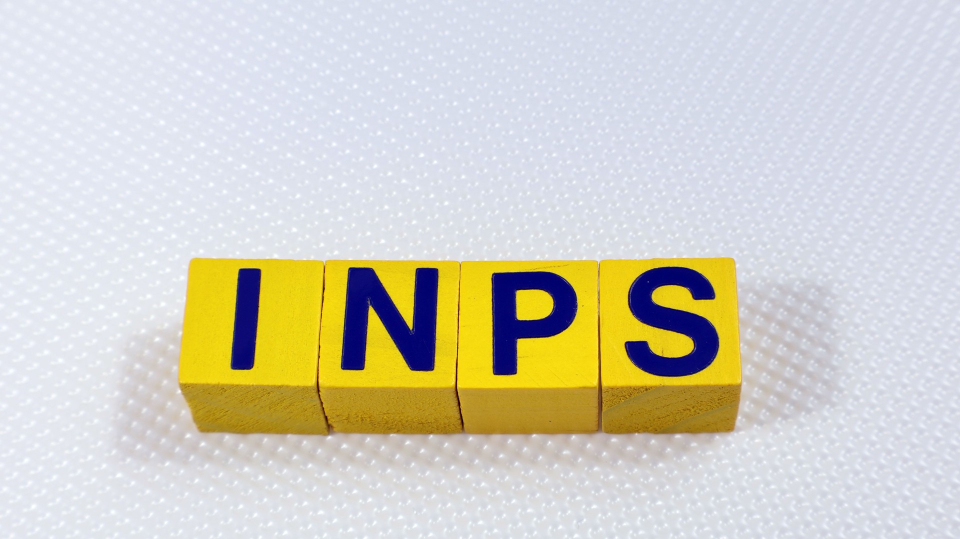 Single Word "INPS" On Wooden Block